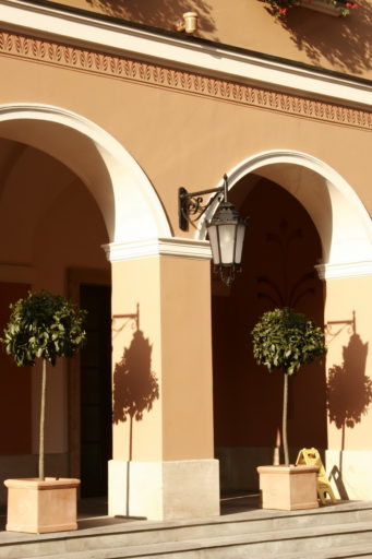 Fasada budynku z arkadami w stylu klasycystycznym, wyposażona w kinkiety 21 Leda montowane na ozdobnych, kutych wspornikach.